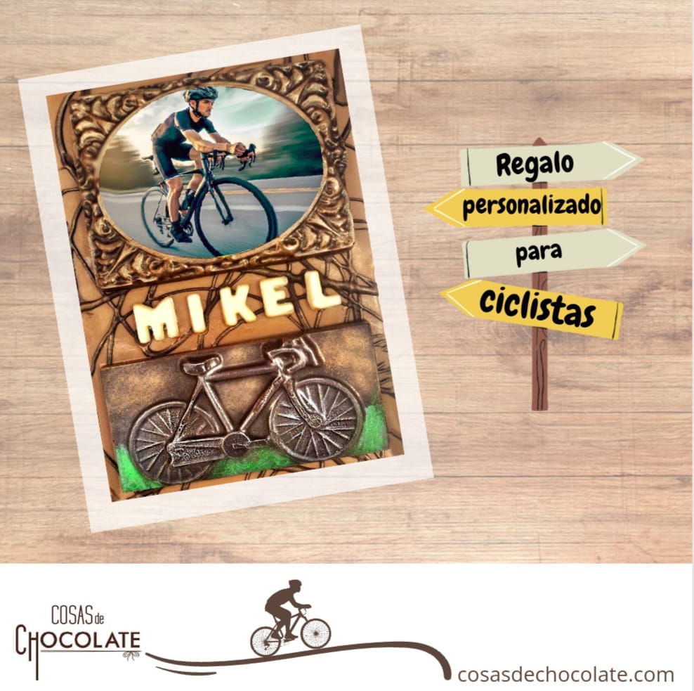 Regalo de chocolate personalizado que tiene como elemento principal una bicicleta de chocolate. Esta personalizado con una foto comestible y el nombre en letras de chocolate.